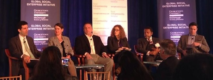 Rural speaker Becky McCray along with a diverse panel of rural entrepreneurship leaders, seated on stage.