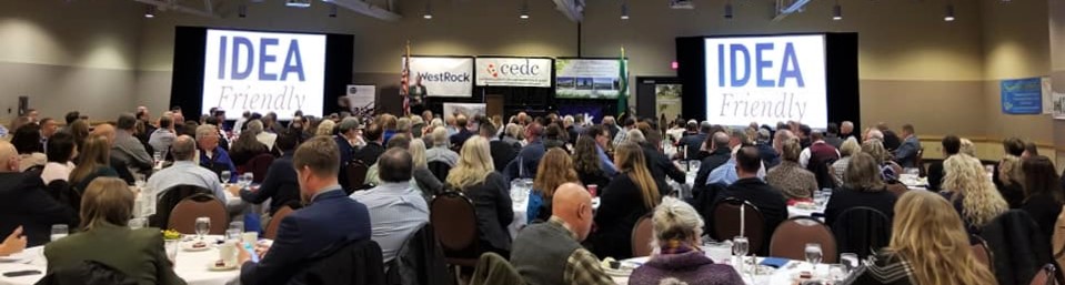 Becky McCray addressing a large audience with "Idea Friendly" shown on the screens