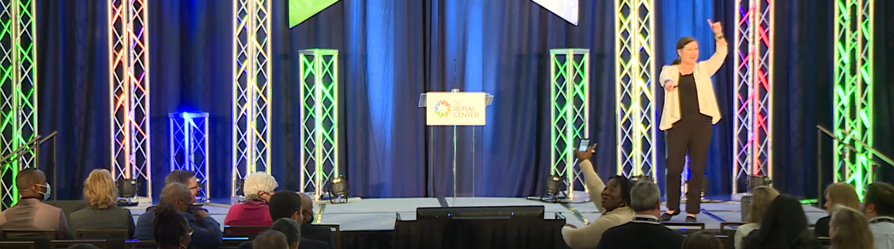 An audience member excitedly waves her arms as she recognizes her community in Becky McCray's keynote speech at the North Carolina Rural Center conference