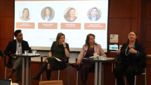 A diverse panel seated on tall chairs, all looking toward Becky McCray as she answers a question.