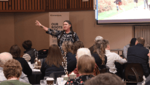 Becky McCray gestures confidently while presenting to a diverse crowd