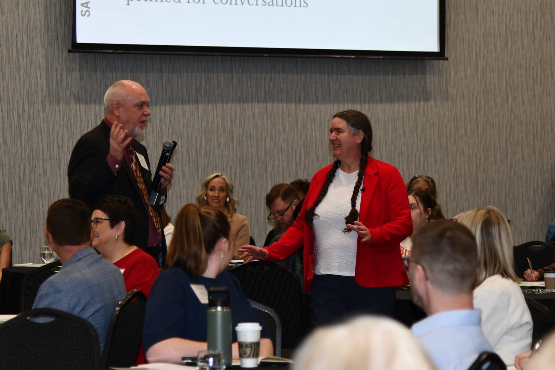 A senior man and Becky McCray interact during a session for community foundations.