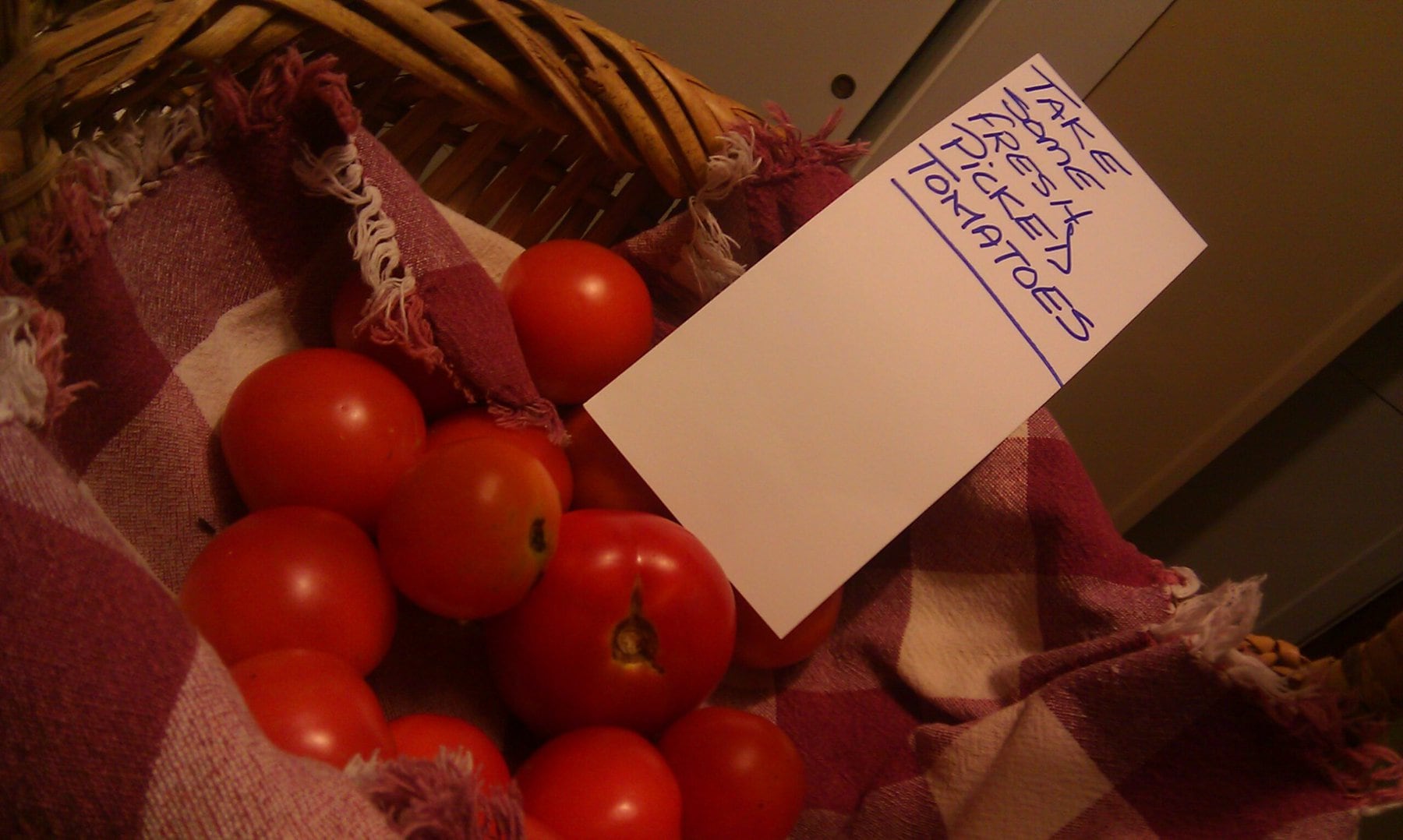 Basket of small tomatoes with a handwritten note: take some fresh picked tomatoes
