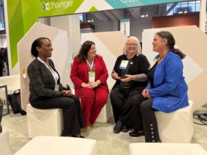 A group of women in conversation in a trade show booth