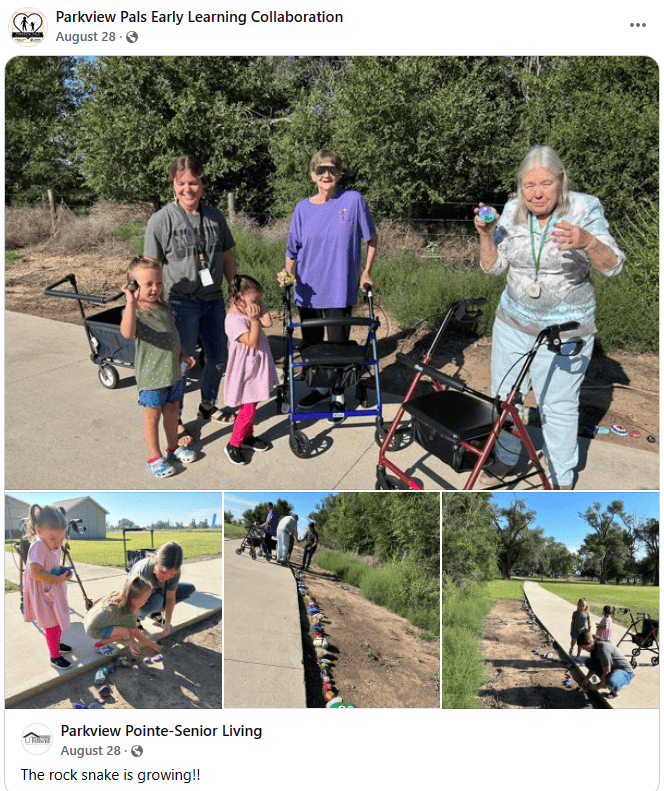 A group of seniors with walkers and toddlers hold up brightly painted rocks.