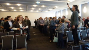 Rural speaker Becky McCray stands on a chair to bring the audience to their feet