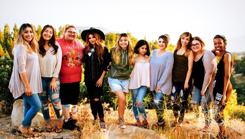 young women stand together in a rural landscape