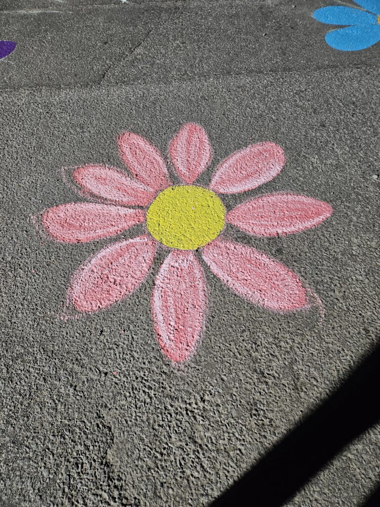 A retro-style pink flower painted on asphalt