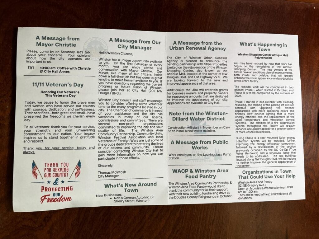 The City of Winston, Oregon paper newsletter laid flat showing multiple columns including messages from the Mayor and City Manager, Veterans Day recognition, new businesses, water district notes, food pantry information, and organizations seeking volunteers.