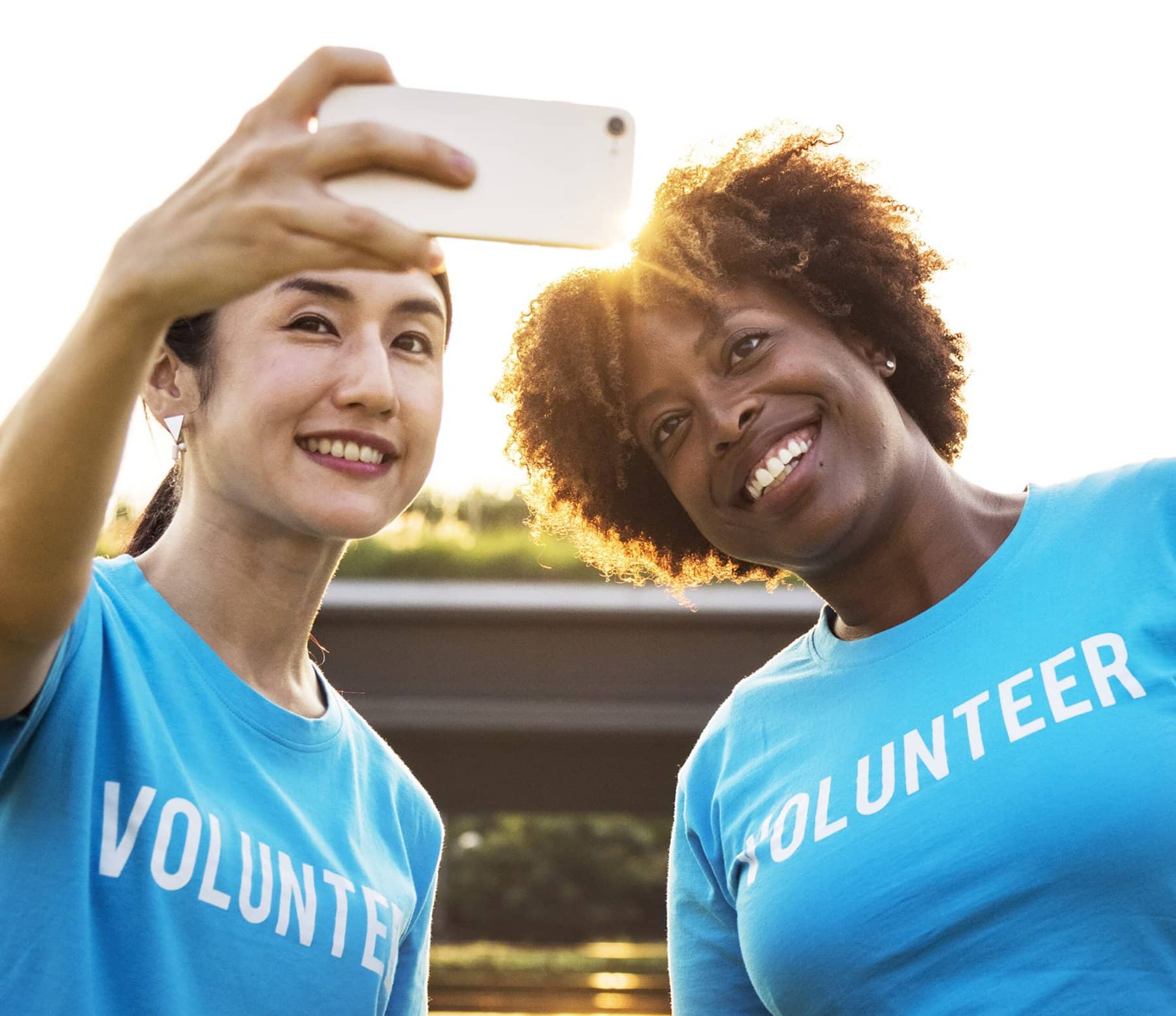 Two volunteers in colorful shirts pause for a selfie